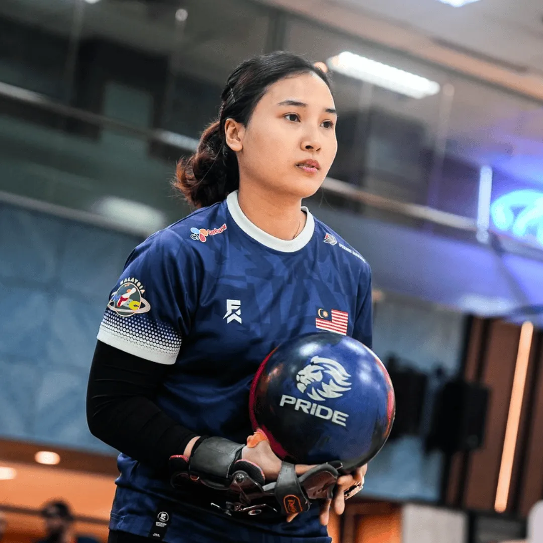 Natasha Roslan standing on the approach with a bowling ball ready to bowl.
