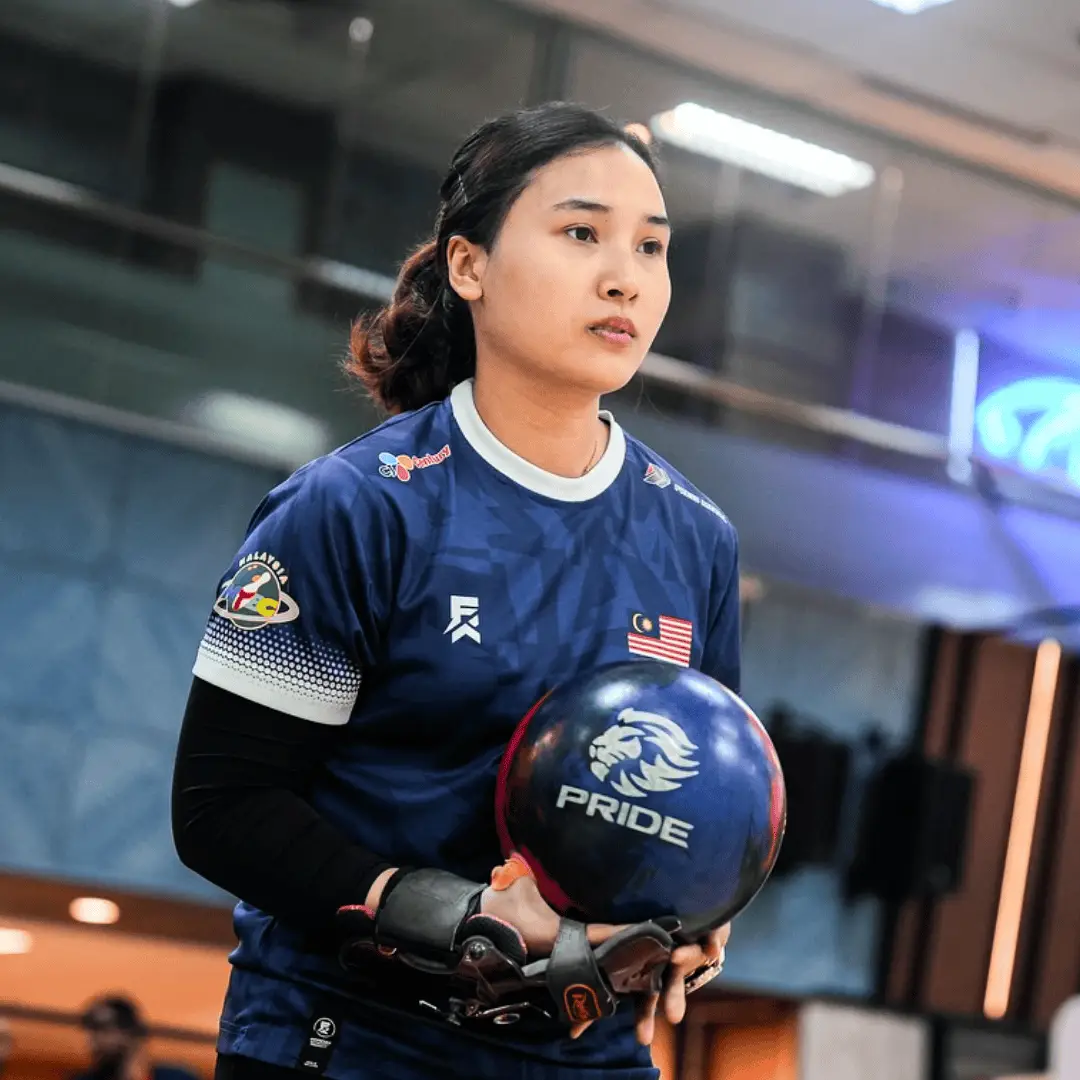 Natasha Roslan standing on the approach with a bowling ball ready to bowl.